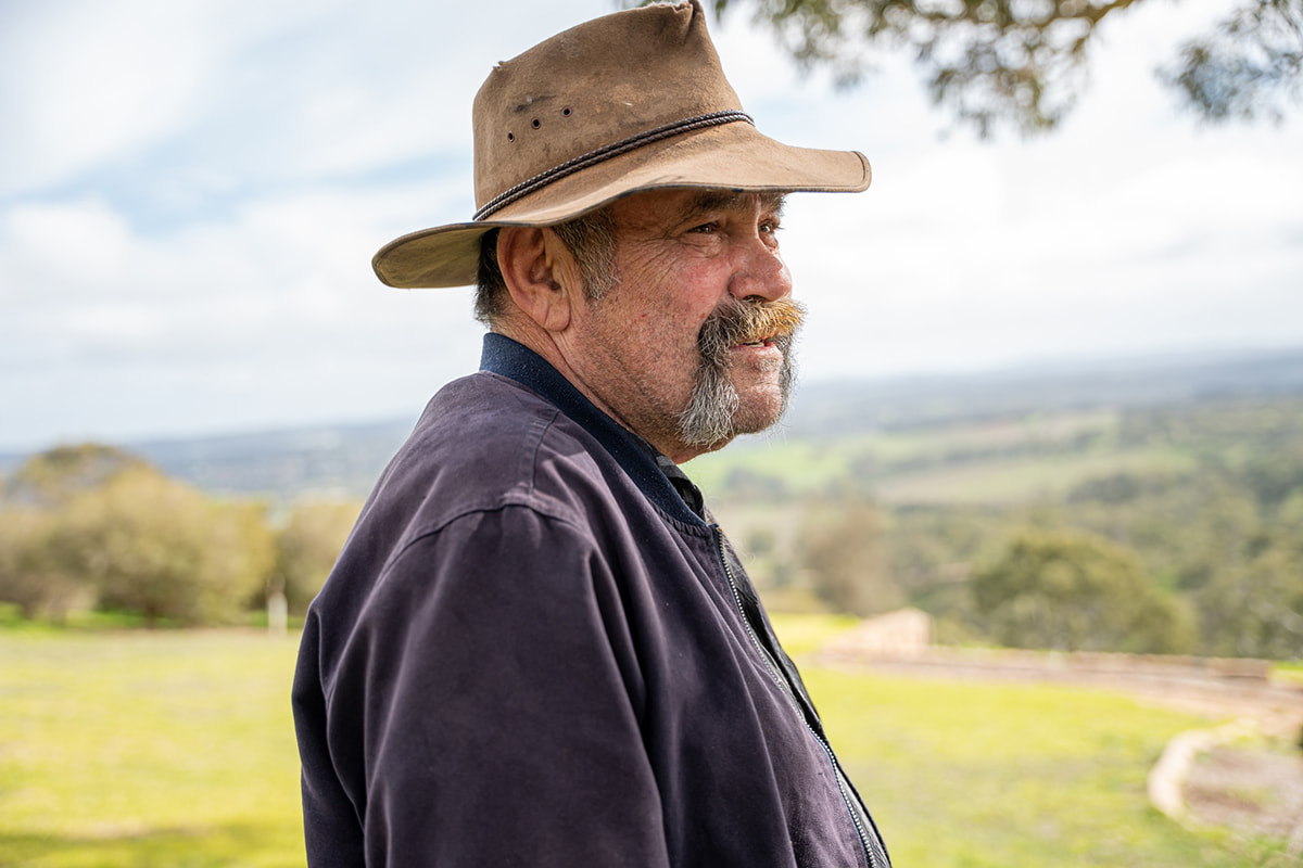 Portrait of Mark Atkins outside in a mountainous setting looking to the right of camera